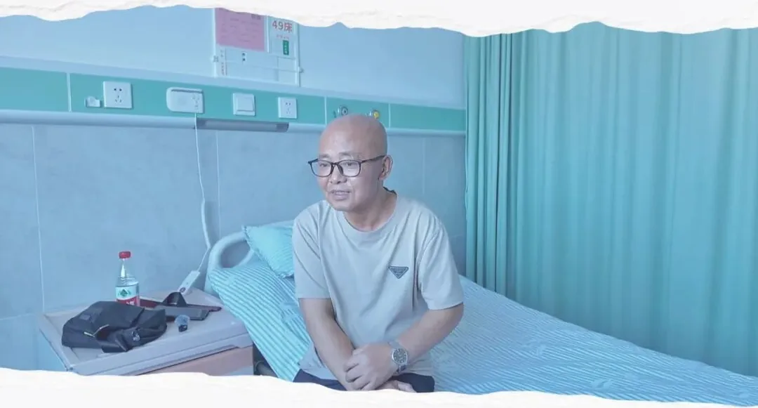 Mr. Shi sitting on his hospital bed during a treatment admission