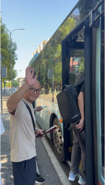 Mr. Shi waving as he boards a public bus home after discharge