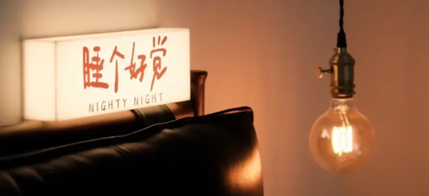 A warm bedside lamp glowing in a dim room